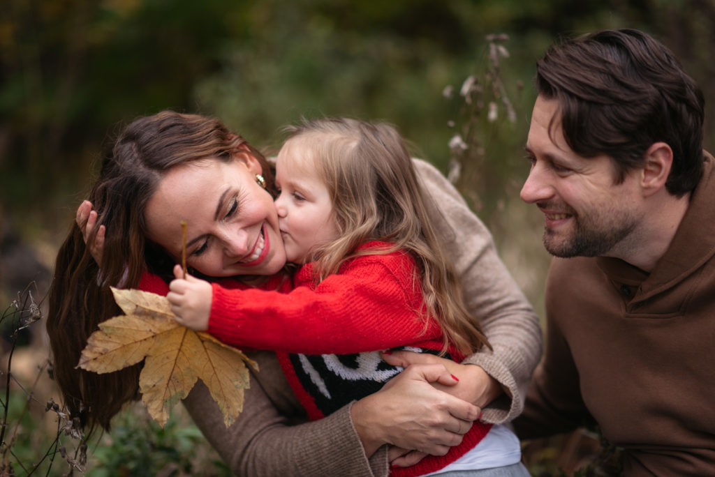 Mamma, dotter och pappa i naturmiljö